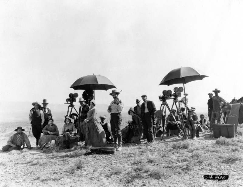 ALAN HALE (3rd from left) Director JAMES CRUZE (in checked jacket near left camera) TULLY MARSHALL (in front of 2 cameras at right) and other Cast Members and Movie Crew (including mood music violinist) on set location candid in Utah in 1922 during filming of THE COVERED WAGON 1923 director JAMES CRUZE novel Emerson Hough costume design Howard Greer producer Jesse L. Lasky Paramount Pictures