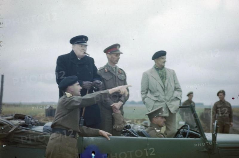 The Visit of the Prime Minister, Winston Churchill To Caen, Normandy, 22 July 1944 The Commander of the 2nd Canadian Corps, Lieutenant General G G Simonds pointing out a section of the front to Mr Churchill. Also standing in the car are the Commander of the British 2nd Army, Lieutenant General Sir Miles Dempsey and the Commander of the 21st Army Group General Sir Bernard Montgomery.