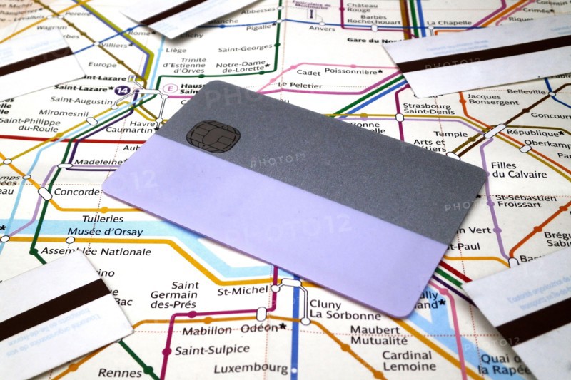 A subway pass card and subway tickets on the top of a Paris Metro map. The allows to travel in all Grand Paris during 2 weeks or one month while subwa