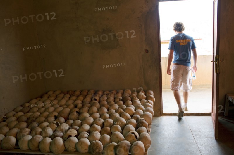 An English public schoolboy leaves a room full of skulls of victims from the 1994 Rwandan genocide .