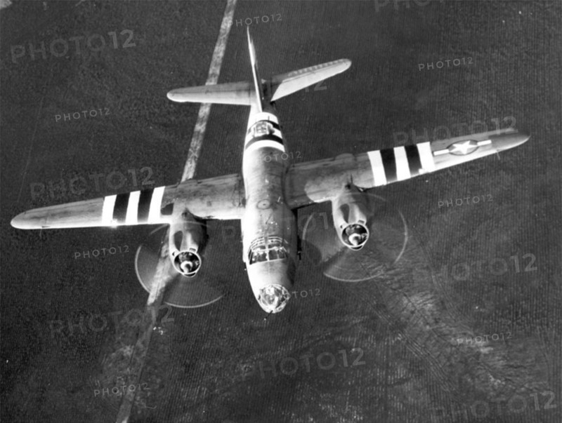 A B-26 Marauder flies with invasion stripes for D-Day.