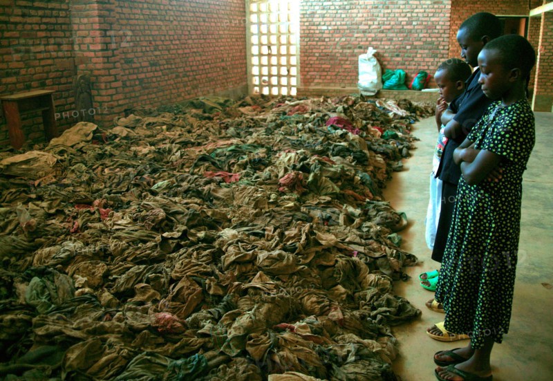 Children standing in a church in rural Rwanda and looking at remains opeople killed during the 1994 genocide