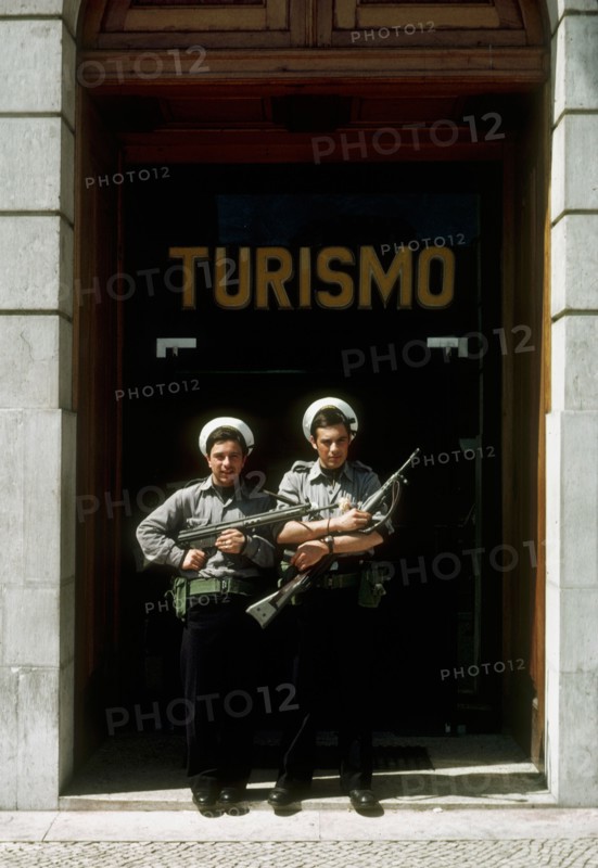 Portuguese marines stand guard outside the tourism office in Lisbon, with flowers in their guns, following the 'Carnation Revolution, the bloodless military coup of 25 April 1974 which deposed the authoritarian Salazar regime and began Portugal's transition to democracy