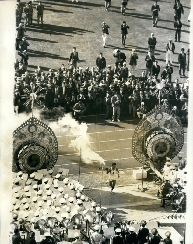 Oct. 10, 1964 - opening Of The Olympic Games In Tokyo: The 1964 Olympic Games was officially opened yesterday in Tokyo-as 7000 athletes 94 nations marched in ceremonial parade in the National Stadium. Photo shows. 19-year old University student, Yoshinari Sakai, who was born in Hiroshima on the day the atomic bomb fell-seen carrying the Olympic torch as he runs between the 'flame drums' at the National Stadium, during yesterday's opening ceremony.