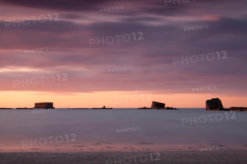 Parts of the remains of the Mulberry Harbour on gold beach Asnelles Calvados Normandy captured at sunset