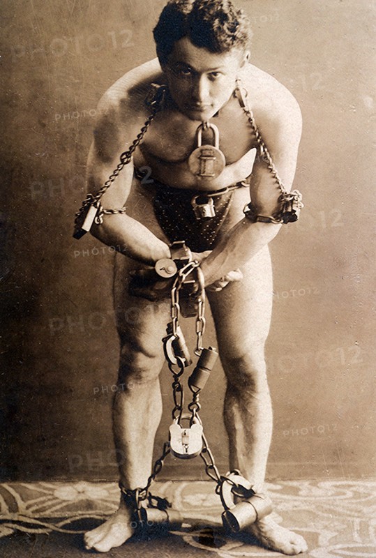 Harry Houdini, full-length portrait, standing, facing front, in chains, circa 1899.  File Reference # 1003_079THA