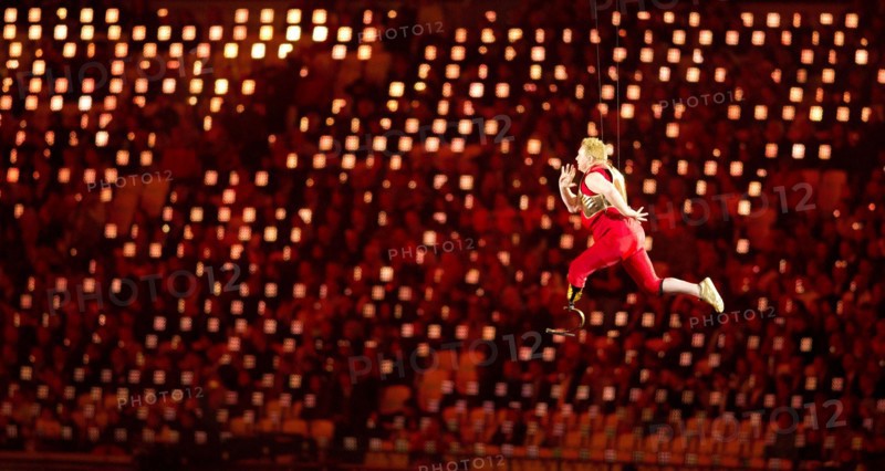 London England, August 29 2012: A disabled athlete, suspended by invisible wires, appears to run through the air above the stadium floor during the Opening Ceremonies of the 2012 London Paralympic Games. ©Bob Daemmrich