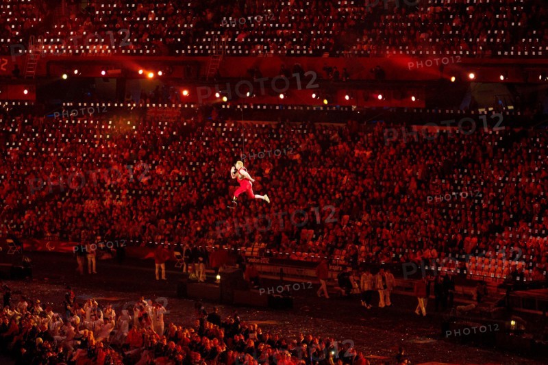 London England, August 29 2012: A disabled athlete, suspended by invisible wires, appears to run through the air above the stadium floor during the Opening Ceremonies of the 2012 London Paralympic Games. ©Bob Daemmrich