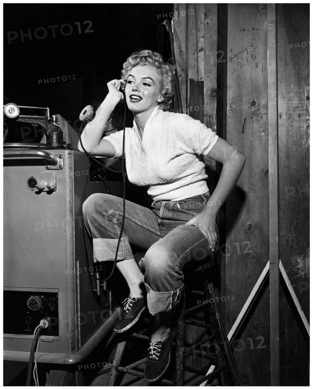 1951 , september , HOLLYWOOD , USA : The american actress MARILYN MONROE ( 1926 - 1962 ) in blue jeans during the making-of  movie CLASH BY NIGHT ( 1952 - La confessione della signora Doyle ) by Fritz Lang for RKO . In this photo with headphones at sound department on the set . Pubblicity still from unknown photographer .- CINEMA - movie - portrait - ritratto - blond hair - capelli biondi  - sex symbol - sex-symbol  - DIVA - DIVINA  - SMILE - SORRISO - bionda - blonde -  ANNI CINQUANTA - 50's - '50 - BLUE JEAN pants - pantaloni  - DENIM ---  Archivio GBB