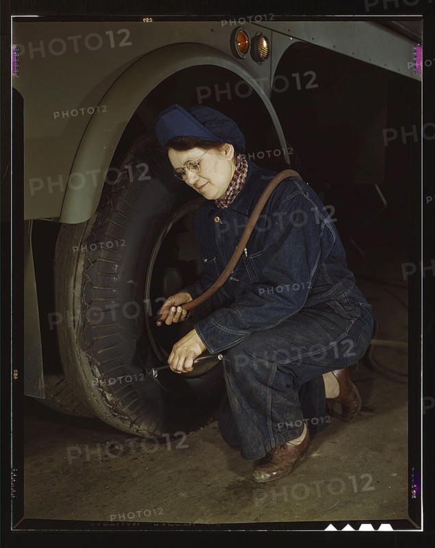 War production workers at the Heil Company making gasoline trailer tanks for the U.S. Army Air Corps., Milwaukee, Wisconsin. Mrs. Angeline Kwint, age 45, an ex-housewife, checking the tires of trailers. Her husband and son are in the U.S. Army (LOC)