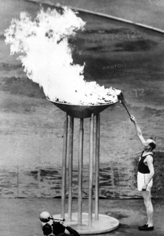 Paavo Nurmi lights the torch at the opening ceremony
