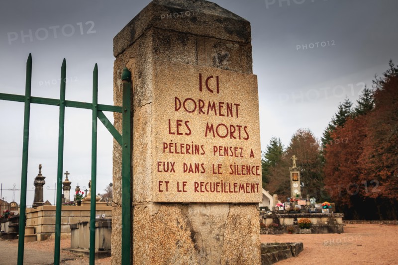 ORADOUR SUR GLANE, FRANCE - December 03, 2017 : at the entrance of the cemetery a stone plaque where it is written - here sleep the dead pilgrims thin