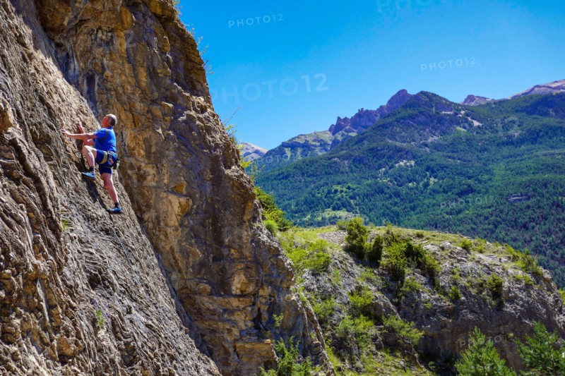 Mature male rock climber on a cliff in the Ecrins National Park, near Briançon, France