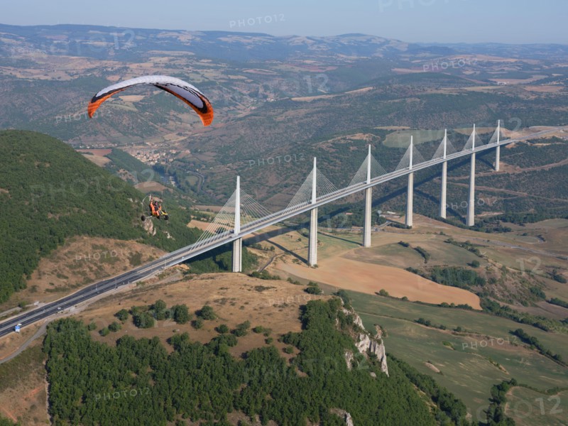 AIR-TO-AIR VIEW. Paramotor flying in the vicinity of the Millau Viaduct, the world's tallest bridge as of 2020. Millau, Tarn Valley, Aveyron, France.