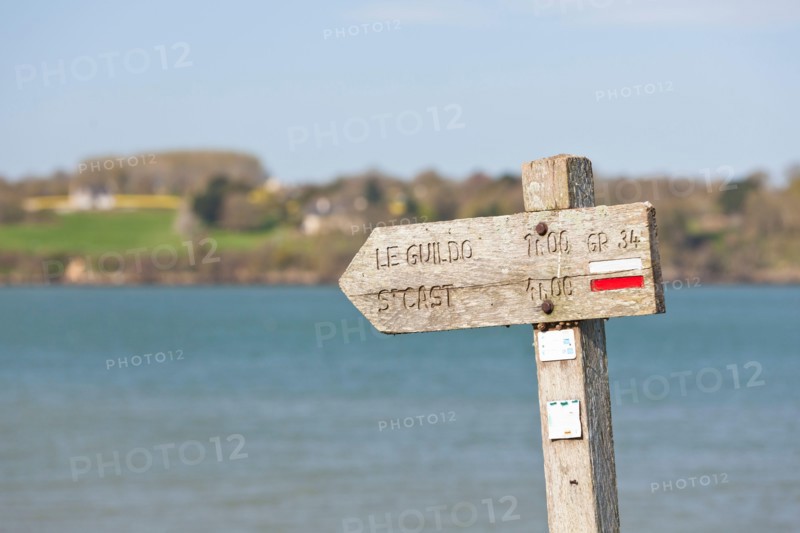 The old wooden sign shows coastal hikers the way to Saint Cast le Guildo along the GR34 long-distance hiking trail between St. Malo and Cap Frehel, Brittany, France