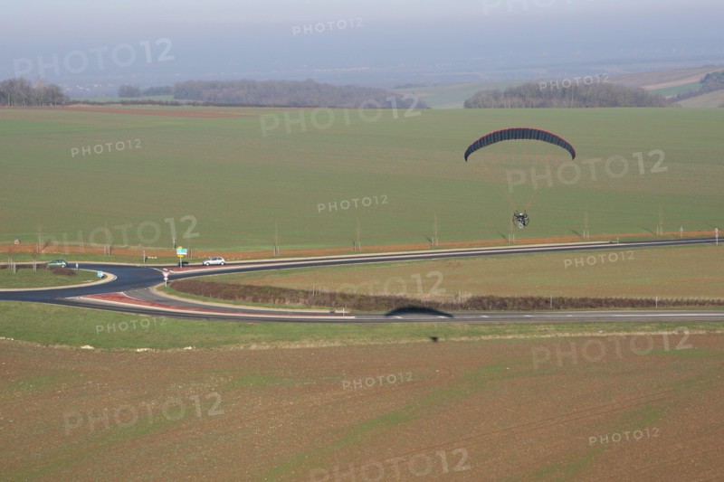 Aerial photograph of a paramotor (motorized paraglider) flying over a roundabout in soindres fields, Yvelines department (78200), Ile-de-France region