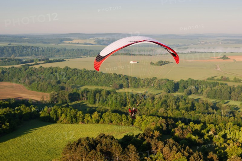 In morning, one paramotor flying over the fields in Yonne department, in Bourgogne-Franche-comté region, France