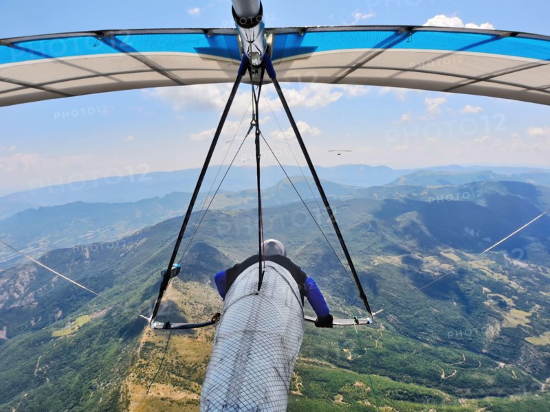 Hang glider pilots race on high altitude above mountain ridges. Extreme sports