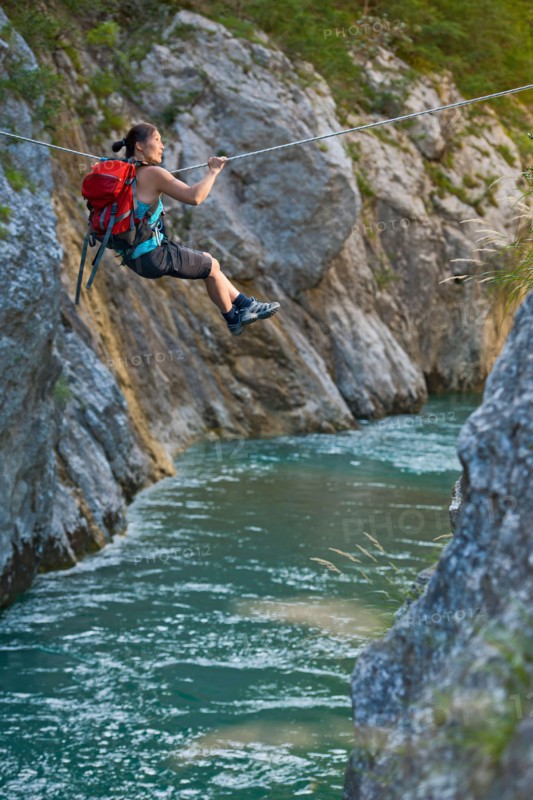 Woman crossing river on Tyrolean traverse  in the Verdon canyon