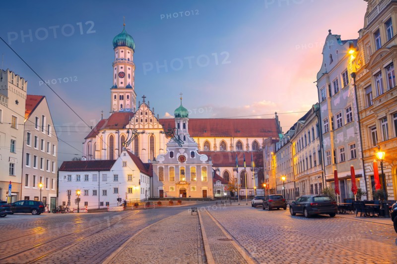 Augsburg, Germany. Cityscape image of old town street of Augsburg, Germany with the Basilica of St. Ulrich and Afra at autumn sunset.