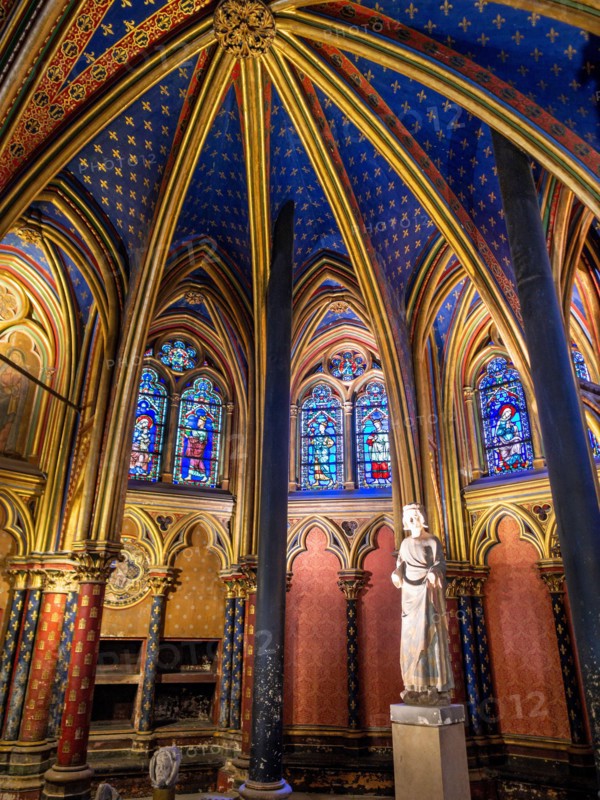 Statue of Saint Louis in Sainte Chapelle: Extravagant arches gilded with gold in a deep blue ceiling frame a statue of Statue of Saint Louis  Louis IX at the front of the lower floor of the famous chapel.