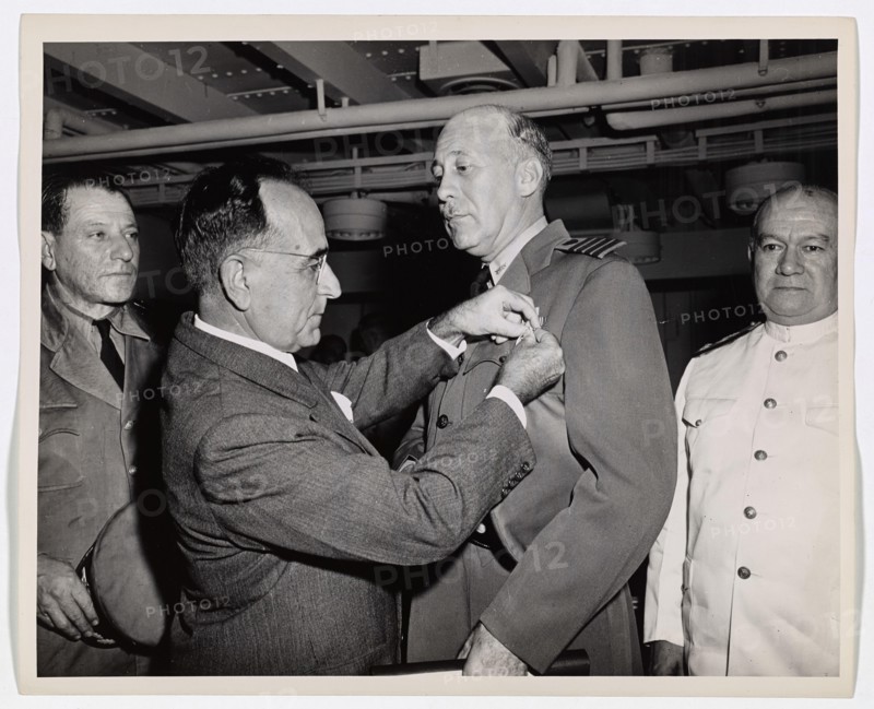 Coast Guard Skipper Decorated by Brazilian President. Coast Guard Captain George W. McKean, Skipper of a troop transport in the Atlantic, is presented with the Medal of Military Merit by President Getulio Vargas of Brazil. The award was made by the Brazilian Government for Captain McKean's safe transporting of elements of the Brazilian Army to the European War Theatre. The troops of the South American republic went overseas aboard a Coast Guard-manned troop transport. Captain McKean's home is at 4122 Vincennes Place, New Orleans, LA.