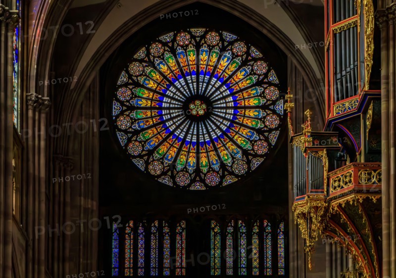 Strasbourg, France - June 3, 2023: Ornate stained glass rose window and organ in the beautiful Gothic cathedral of the Notre Dame, historic center