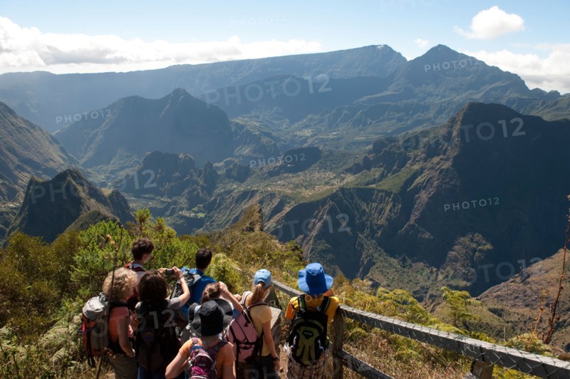 Hikers look down to the Mafate Cirque at a viewpoint on the Maido Peak.