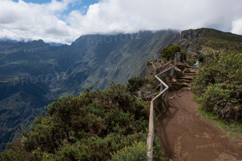 French Overseas Territory, Reunion Island. Scenic overlook into the Cirque of Mafate volcanic caldera, 2090 meters high. Tourists on the rim overlook