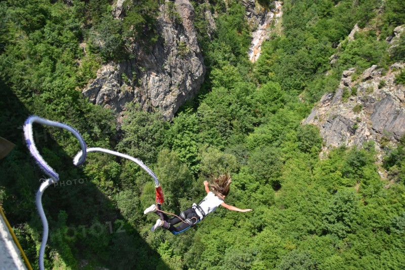 Young woman bungee jumper jumping from a 230 feet high viaduct