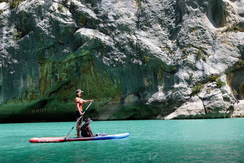 Mother and son paddling on SUP on turquoise water of Gorge du Verdon Provence France