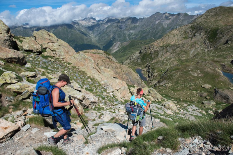 Walkers descend from the top of Pic Peyreget while hiking the GR10 trekking trail, Pyrenees Atlantiques, France, Europe