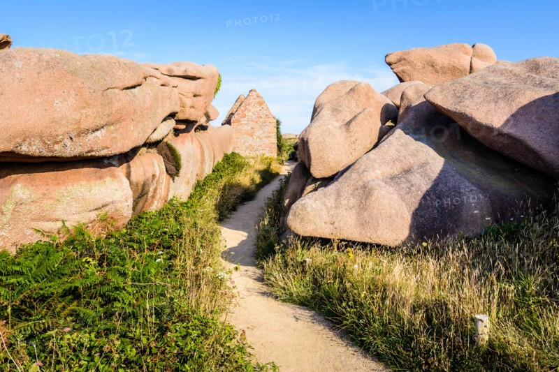 Ruins of a former gunpowder store on the GR34 coastal path in the granite blockfield of Ploumanac'h on the Pink Granite Coast in Brittany, France.