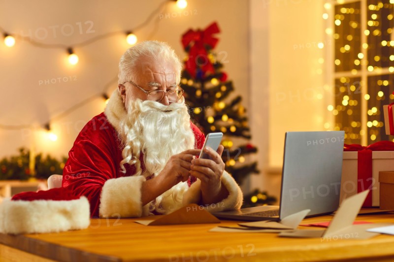 Modern Santa using mobile to read emails from children and order presents delivery