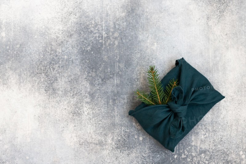 Furoshiki style gift for Christmas or New Year on a white background. Flat lay. Copy space.