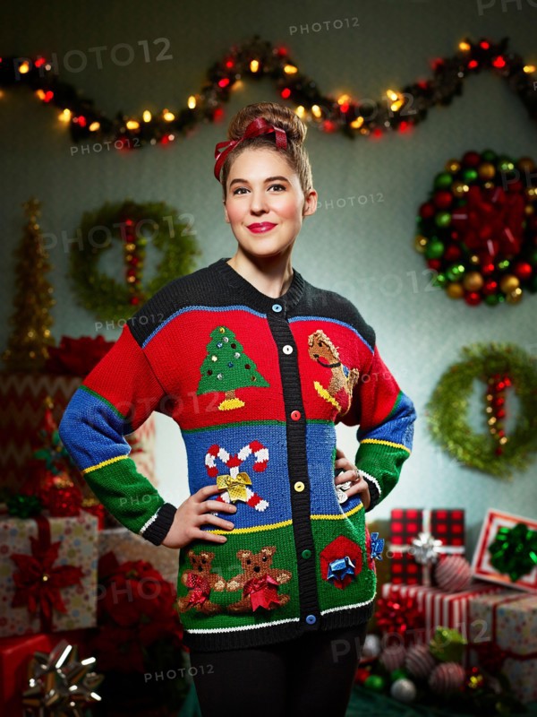 Portrait of woman in ugly Christmas sweater looking into camera with pride