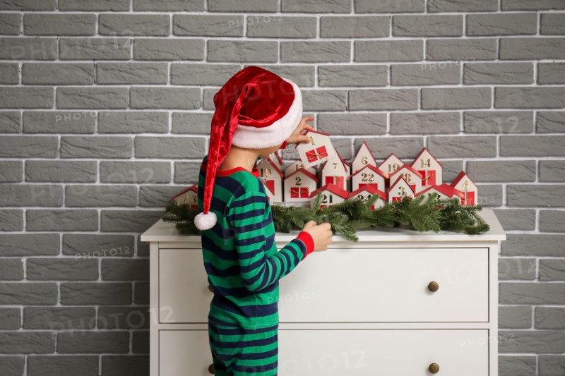 Little boy with Christmas advent calendar at home