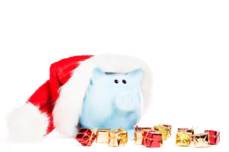 piggy bank wearing santas hat with tiny christmas presents on white background
