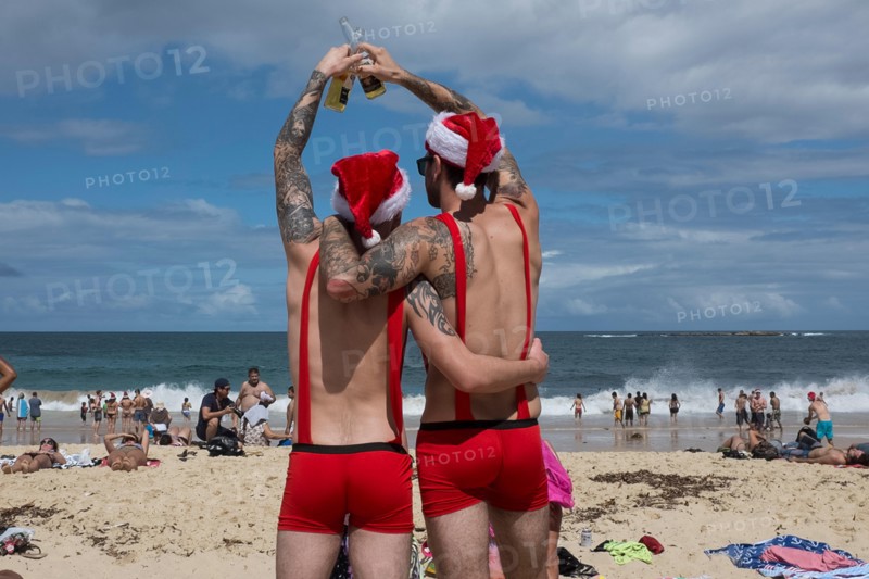 men toasting a merry christmas on Coogee beach, Sydney, New South Wales, Australia