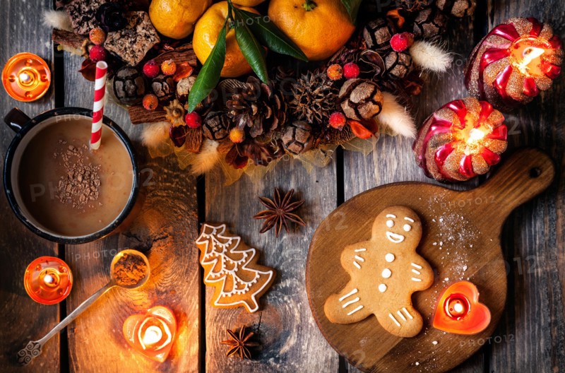 Christmas homemade gingerbread cookies, hot chocolate and candles on wooden table