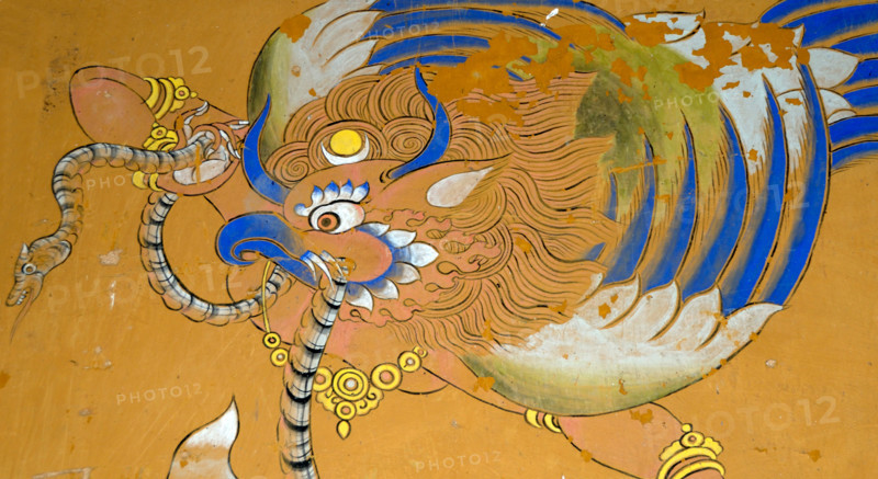 Mural of a Garuda painted in traditional Bhutanese style on a wall in Wangdichholing Dzong. It has a snake, naga, in its beak.