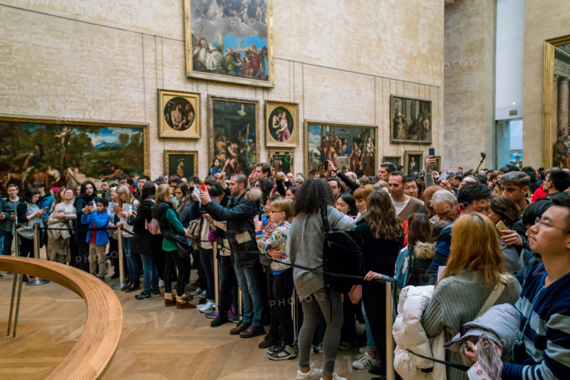 PARIS, FRANCE - FEBRUARY 15, 2018: Visitors take photo of Leonardo DaVinci's "Mona Lisa" at the Louvre Museum