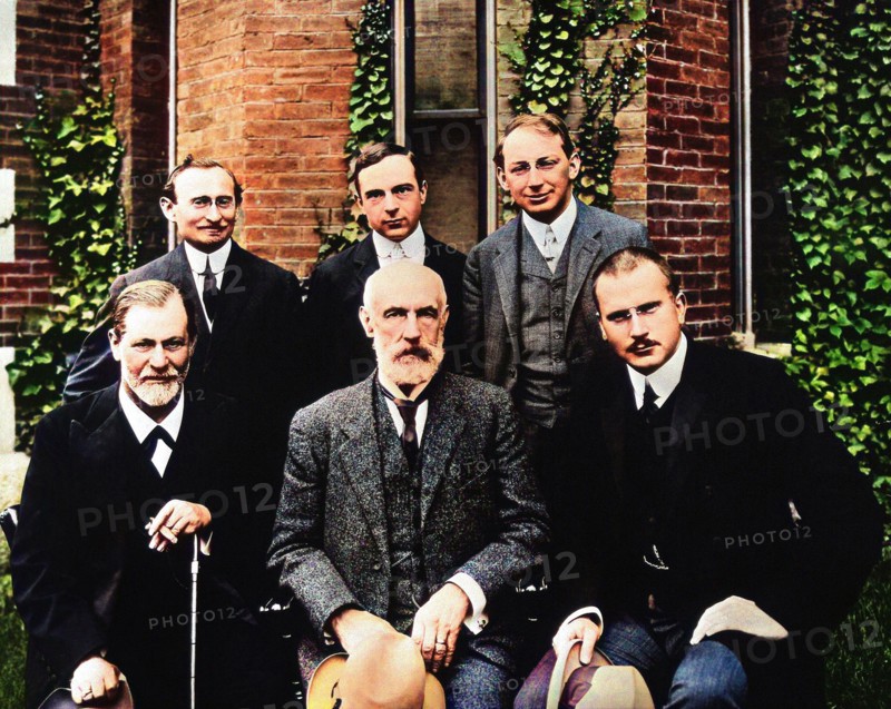 1909 , GREAT BRITAIN : The german Doctor Professor CARL Gustav JUNG ( 1875 - 1961 ) at Clark University , first from right side . The others from the left : SIGMUND FREUD ( 1856 - 1939 ), STANLEY HALL , standing ABRAHAM ARDEN BRILL , ERNEST JONES and SANDOR FERENCZI . Unknown photographer . DIGITALLY COLORIZED .- HISTORY  - foto storiche - foto storica  - scienziato - scientist  - portrait - ritratto  - PSICANALISTA - SESSUOLOGIA - SESSUOLOGO  - barba - beard  - DOTTORE - MEDICO - MEDICINA - medicine  - SCIENZA - SCIENCE -  SEXOLOGY - SEX - SESSO - PSICOANALISI - PSICANALISI - PSYCOANALYSIS -