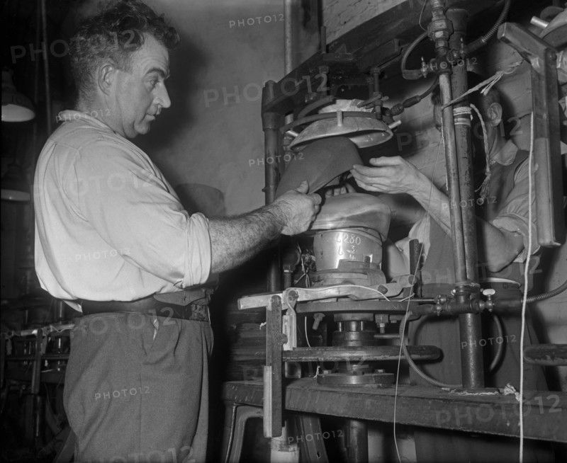 Flat cap being pressed on to a mould at the Denham and Hargreaves factory, Atherstone. Circa 1960