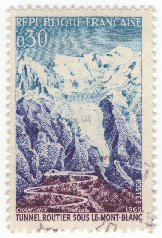 FRANCE - 1965 July 17: An 30 centimes blue, violet-blue and brown-violet postage stamp depicting Road and tunnel, Mont Blanc. For the opening of the Mont Blanc Tunnel, a highway tunnel between France and Italy, under the Mont Blanc mountain in the Alps. The passageway is one of the major trans-Alpine transport routes, particularly for Italy, which relies on this tunnel for transporting as much as one-third of its freight to northern Europe. It reduces the route from France to Turin by 50 kilometres and to Milan by 100 km