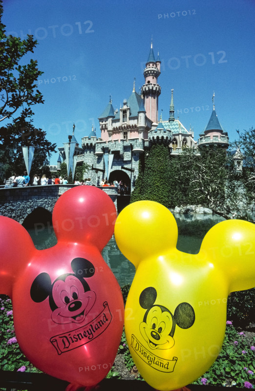 Brightly-colored balloons with the face of Mickey Mouse float in front of Sleeping Beauty Castle, an imposing fairy-tale structure that is the centerpiece of the world’s most famous theme park, Disneyland, which opened in 1955 in Anaheim, California, USA.  The building was modeled after a real castle, Neuschwanstein, constructed in Germany in the late 1800s as a palace for King Ludwig II of Bavaria.  Disneyland was the creation of Walt Disney, a well-known American entrepreneur and filmmaker who created Mickey Mouse and other iconic cartoon characters.
