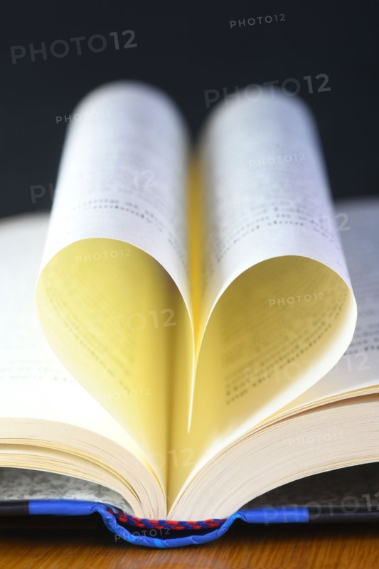 vertical heart shaped book pages showing spine ,selective focus on a black background concept of the love of reading
