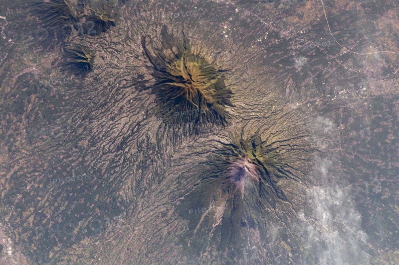 The Earth seen from the International Space Station: A smoking Mount Merapi (lower) and Mount Merbabu (top), Java, Indonesia, 10 May 2021. Mount Merapi is a highly active volcano in Central Java.  An optimised and enhanced version of a NASA image / credit NASA.