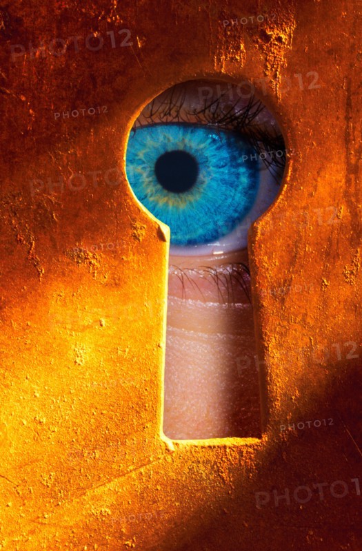 Eye peering through a keyhole