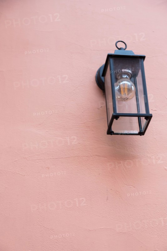 Old lantern with a white lamp. Wall color - Oriental Pink, Hue Red. Vintage lantern concept.